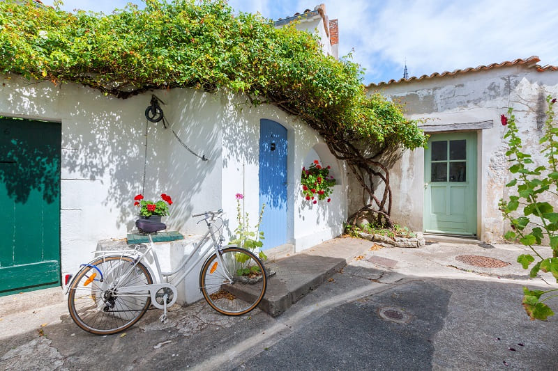 Prenez le temps de découvrir les venelles fleuries de roses trémières au rythme lent des vélos lors de votre séjour en chambre d'hôtes Les Fillattes